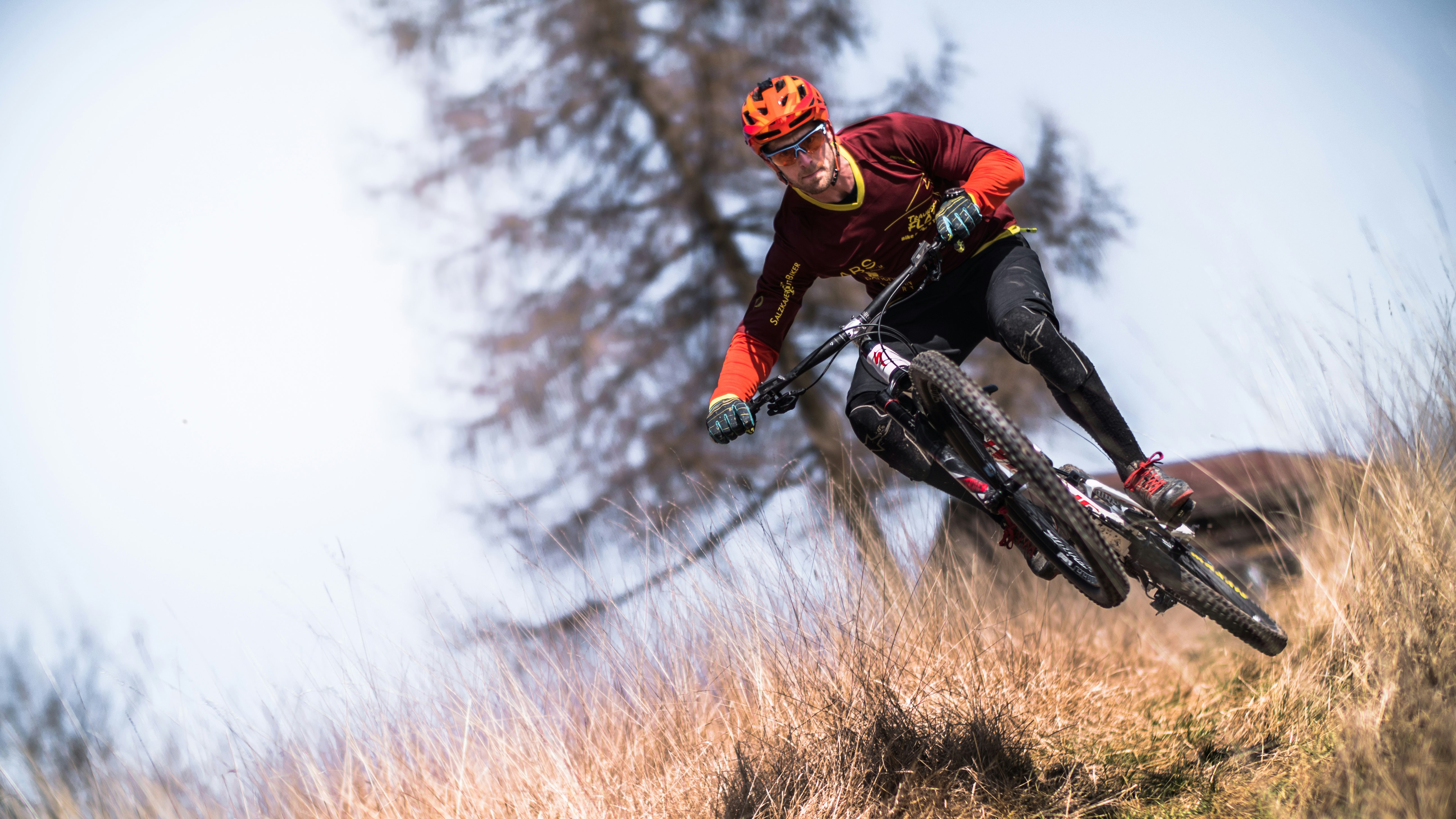 man riding bicycle on brown grass at daytime